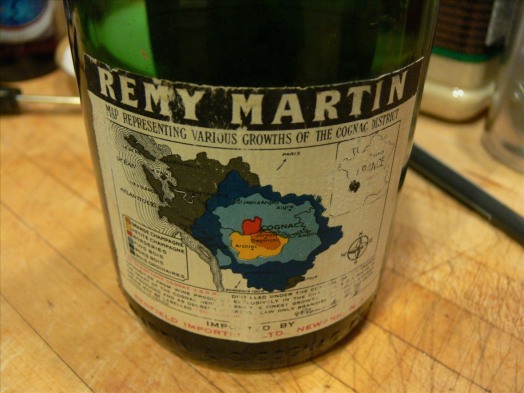 Vecchia bottiglia di cognac Remy Martin con la carta dei crus in etichetta.